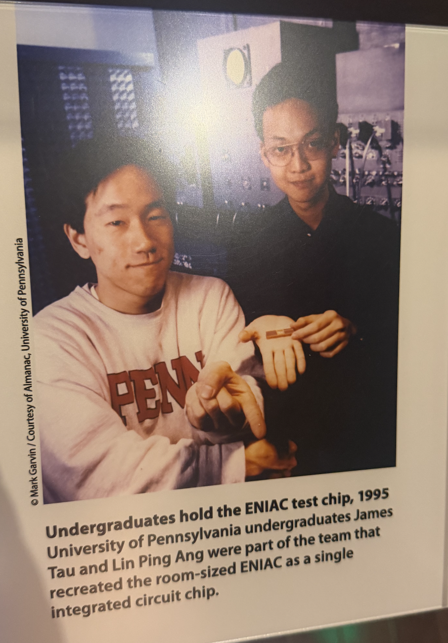 ENIAC reimagined on a single chip, held by UPenn undergraduates James Tau and Lin Ping Ang, 1995